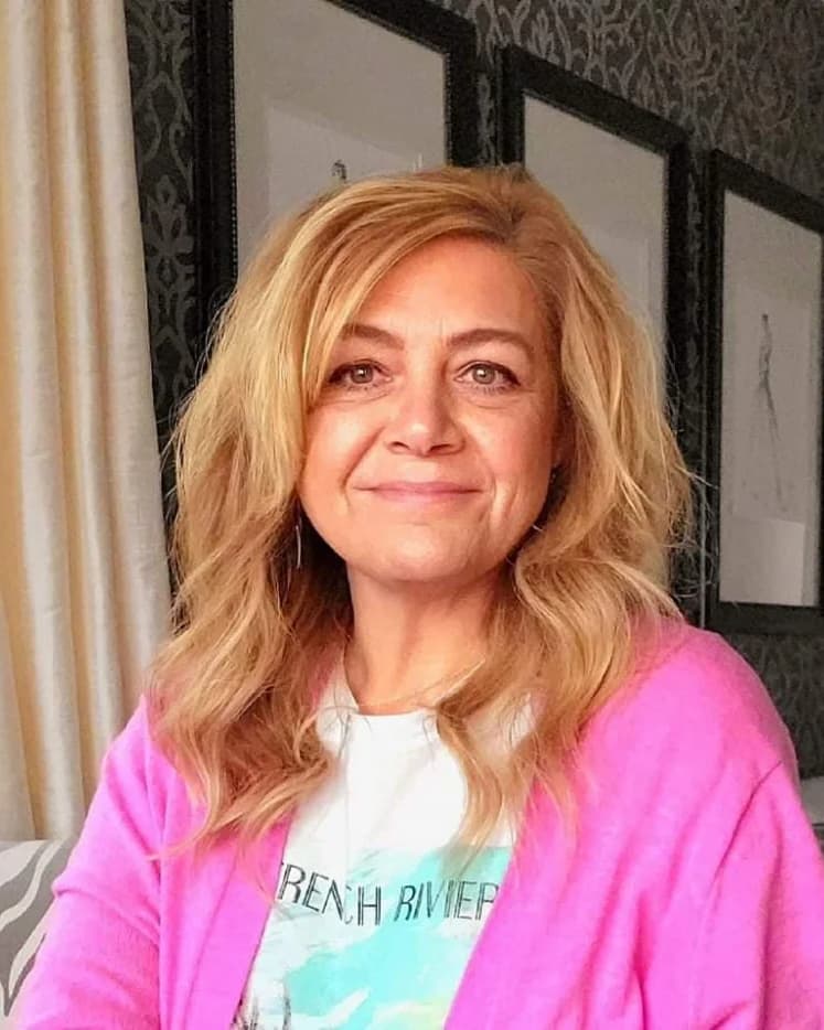 Becky, founder and creative director of Revel & Rare Occasions, smiling in a pink cardigan