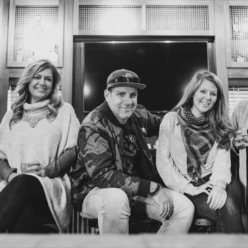 Black and white photo of an event team of five seated together at a bar