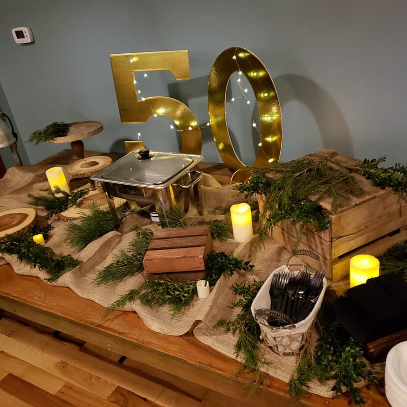 Rustic 50th birthday display with marquee numbers, gold balloons and wooden crates