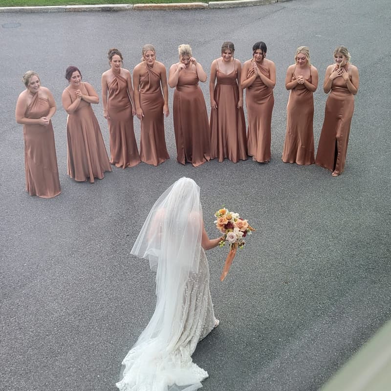 Bride and bridesmaids in terracotta dresses photographed from above