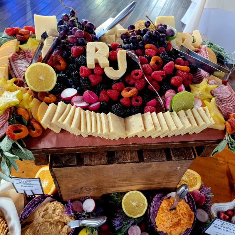 Charcuterie board with fruit, cheese and the initials R and J